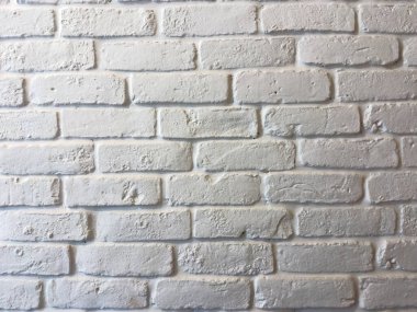Yumuşak gün ışığı altında pürüzsüz alçı detaylar ve ince gölgeler gösteren desenli beyaz tuğla duvar