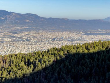 Atina, aydınlık bir öğleden sonra İmettus Dağı 'ndan gökyüzüne yükseldi