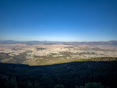 Atina şehir manzarası açık gökyüzünün altındaki Hymettus Dağı 'ndan, geniş banliyöler ve uzak tepelerden izlendi