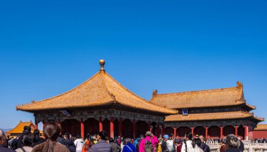 Pekin, Çin, 25 Mart 2025. Turistler Yasak Şehir 'de altın çatılar ve kırmızı duvarlar keşfediyor. Geleneksel mimari, güneşli bir gün..