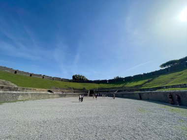 Pompeii, İtalya, 19 Ekim 2023. Antik amfitiyatro, arenada ziyaretçiler, güneşli bir gün. Roma mimarisi ve tarihi miras.