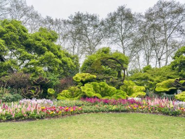 Topçu sanatı heykelleri, Batı Gölü bahçesi, Hangzhou, Çin. Nilüfer çiçekleri ve yapraklar şekilli heykeller, yemyeşil ağaçların yemyeşil arka planı.