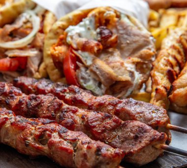 Dilimlenmiş jiroskoplu et, pide, domuz şiş, souvlaki, geleneksel sokak yemekleri, yakın çekim manzarası.