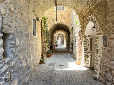 Yunanistan 'ın Chios Adası' ndaki Mesta ortaçağ köyünde dar bir sokak. Antik taş duvarlar, kaldırım taşları ve taş kemer. Geleneksel mimari