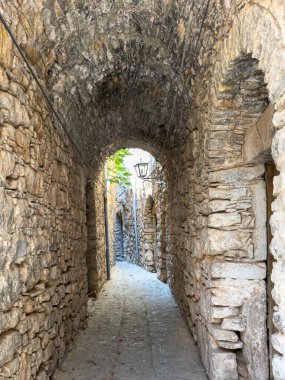 Chios Adası, Yunanistan. Mesta Ortaçağ köyü dar sokağı, Antik taş duvarlar, kaldırım taşları ve taş kemer. Geleneksel mimari