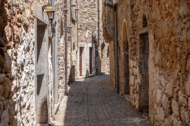 Mesta ortaçağ köyü. Chios Adası, Yunanistan. Dar kaldırım taşı sokağı, geleneksel mimari taş evler ve kemer. Kırsal ahşap kapılar ve pencereler
