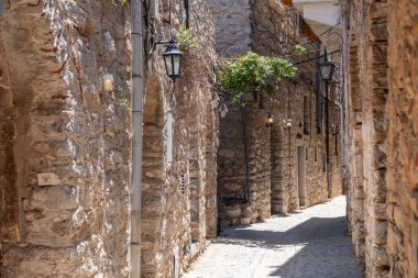 Mesta mastik köyü. Chios Adası, Yunanistan. Dar kaldırım taşı sokağı, geleneksel mimari taş evler ve kemer. Kırsal ahşap kapılar ve fenerler