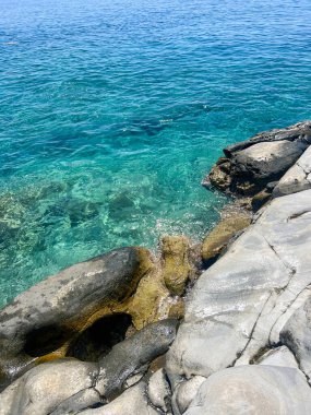 Yunanistan 'ın Girit adası kıyısı boyunca turkuaz deniz ve büyük kayalar. Sakin şeffaf su ve pürüzsüz taş dokular, yaz tatili beldesi