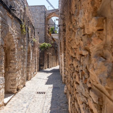 Mesta ortaçağ köyü. Chios Adası, Yunanistan. Dar kaldırım taşı sokağı, geleneksel mimari taş evler ve kemer. Kırsal ahşap kapılar ve fenerler