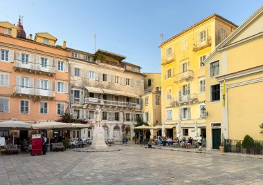 Korfu Eski Kasabası, Yunanistan, 5 Haziran 2025. Heroes Meydanı 'ndaki Theotokis heykeli, Venedik binaları ve kafe terasları