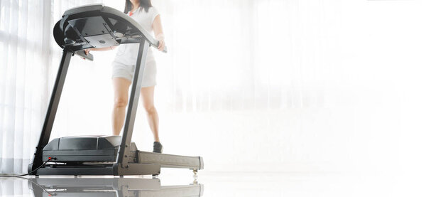 Sporty woman training on treadmill at home