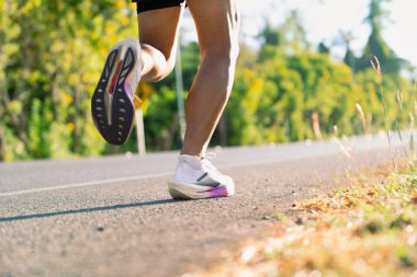 Açık havada koşarken koşucu ayakkabılarını kapat. Fitness egzersizi, spor performansı, dayanıklılık eğitimi ve aktif yaşam tarzı kavramı.