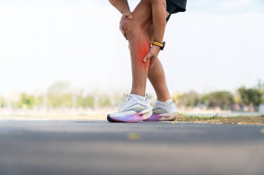 Sporcu koşucu dışarıda koşarken dizini tutuyor. Spor sakatlığı, diz ağrısı, aşırı antrenman ve egzersiz nedeniyle sağlık sorunu kavramı.