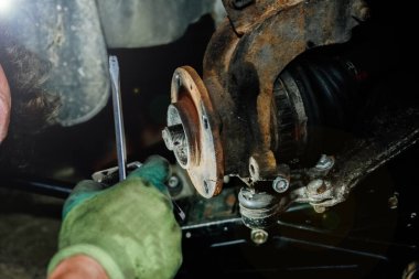 Tamirci araba tekerleği merkezini kaldırır..