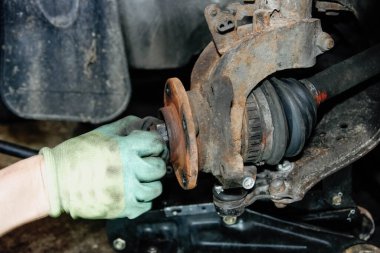 Tamirci araba tekerleği merkezini kaldırır..