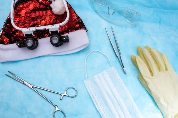 圣诞老人圣诞礼帽背景下的手术器械 医疗面具和眼镜 新年医学观念 — 图库照片
