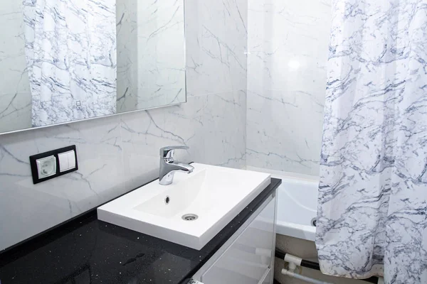 modern bathroom interior, marble tiles, mirror, jacuzzi, white vanity unit.