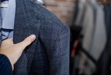  Mağazada ceketi seçen bir adam. Adam alışveriş yapıyor..