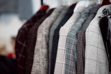 Bir giyim mağazasındaki askıda asılı klasik ceketler. Doğal malzeme, yün, keten pamuk.