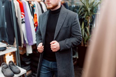  Adam mağazadan kıyafet seçiyor. Adam alışveriş yapıyor..