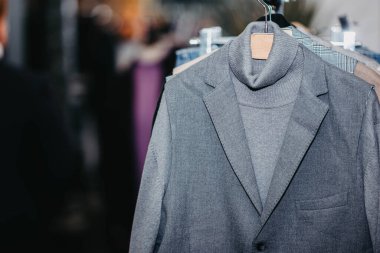 Bir giyim mağazasındaki askıda asılı klasik ceketler. Doğal malzeme, yün, keten pamuk.