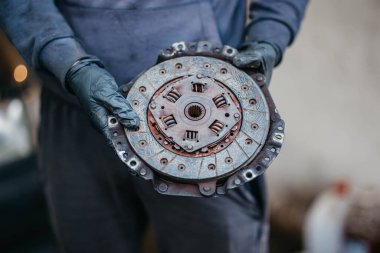 Tamircinin elindeki bir arabanın elle vites kutusunun debriyajı.