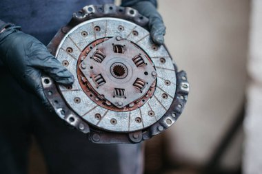 Tamircinin elindeki bir arabanın elle vites kutusunun debriyajı.