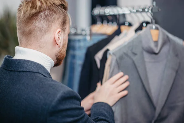 Ένας Άντρας Κατάστημα Ρούχων Διαλέγει Ένα Επαγγελματικό Κοστούμι Για Ψωνίσει — Φωτογραφία Αρχείου