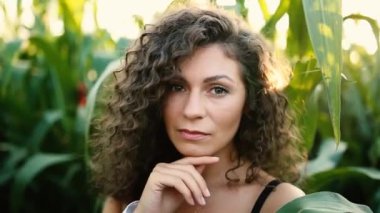 Sahada kameraya poz veren yazlık elbiseli genç bir kızın görüntüleri.