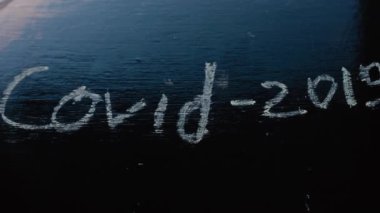 El, tebeşirdeki COVID yazısını siliyor - 19 