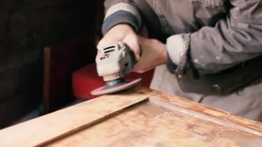 Vernik ve boyayla ahşap işleme sanatı. El yapımı, katı ahşaptan mobilya imalatı. Bir adam kapıyı cilalıyor ve onu boyamaya hazırlıyor.