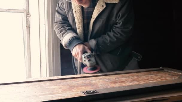男性職人は木の板やキャビネットのドアを電動グラインダーで研削します 家具の修復 — ストック動画