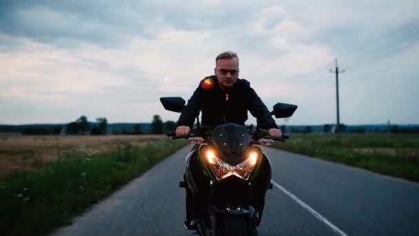 Junger Mann Lederjacke Und Brille Fährt Abends Motorrad Auf Der — Stockvideo