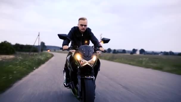 Deri Ceketli Gözlüklü Genç Bir Adam Akşam Yolda Motosiklet Sürüyor — Stok video