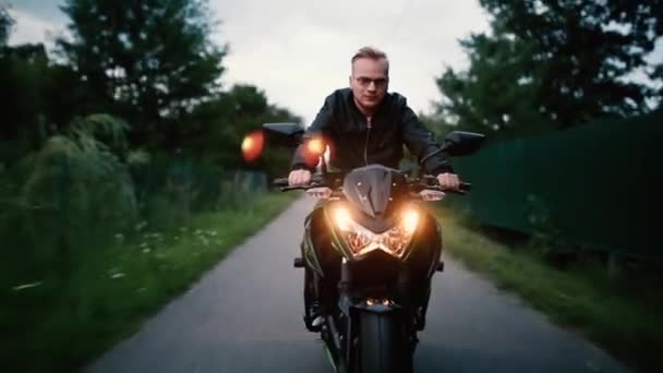 Junger Mann Lederjacke Und Brille Fährt Abends Motorrad Auf Der — Stockvideo