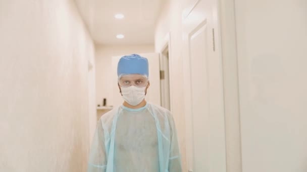 一个严肃的年轻医生走过医院走廊的镜头 — 图库视频影像