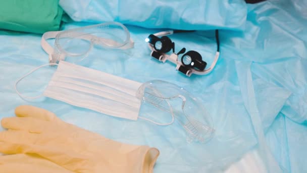 手袋やコロナウイルスの概念を持つ眼鏡やマスクを持つ医師のための医療保護衣装 — ストック動画
