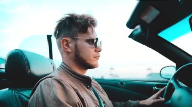 Erkek Cabriolet araba sürücüsü güneşli bir günde güneş gözlüğü takıyor..