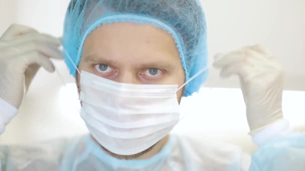 一个年轻医生戴上外科口罩工作的镜头 — 图库视频影像