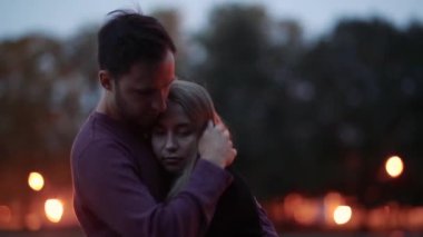 Birbirini seven bir çiftin göl kıyısında birbirlerine sarılışının görüntüleri. 