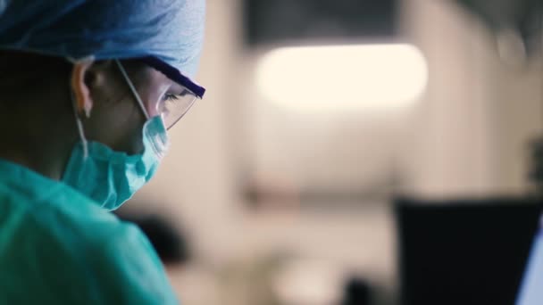 Chirurg Onderzoekt Informatie Patiënt Een Monitor Een Operatiekamer Van Een — Stockvideo