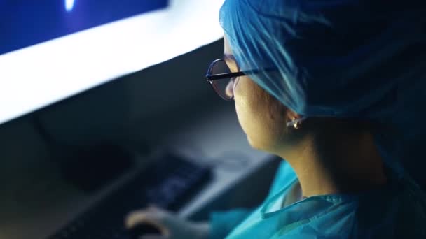 外科医生在医务室手术室的监视器上检查病人的资料 — 图库视频影像