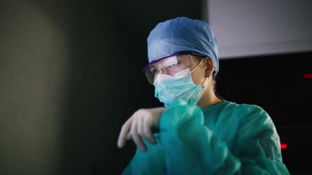 验尸官大流行期间 穿着制服和护目镜的年轻女外科医生在手术室 — 图库视频影像