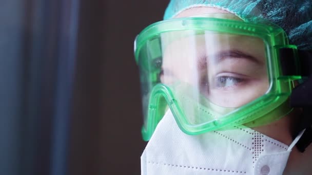 勤務中の保護マスクや医療用眼鏡の女性外科医の目の閉鎖 疫学的保護は — ストック動画