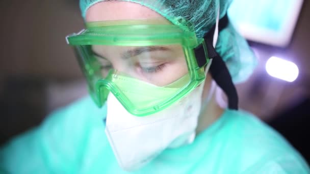 勤務中の保護マスクや医療用眼鏡の女性外科医の目の閉鎖 疫学的保護は — ストック動画