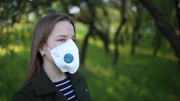 医療用マスクの緑の公園の少女の映像だ 自然エネルギーの中を歩く — ストック動画