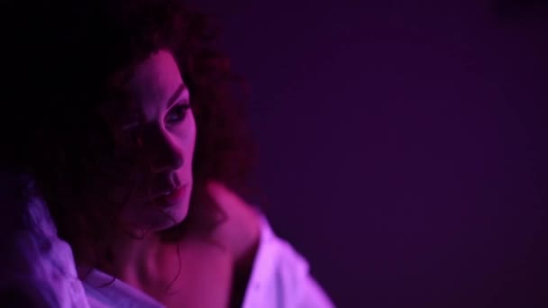 Model Kıvırcık Kadın Neon Işıklarıyla Poz Veriyor Teninde Işık Yansımaları — Stok video