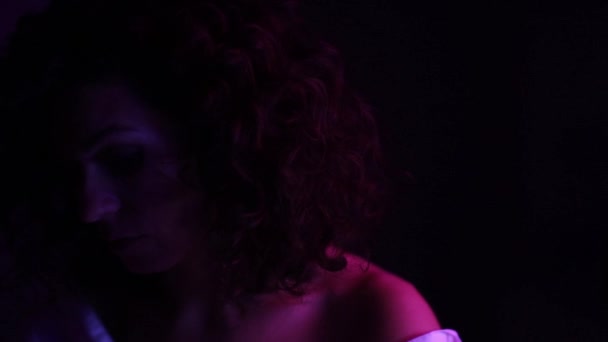 Model Kıvırcık Kadın Neon Işıklarıyla Poz Veriyor Teninde Işık Yansımaları — Stok video