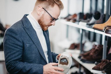 Ayakkabı mağazasındaki adam ayakkabı alır.