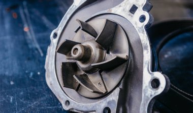 Bir araba motoru ve sürüş kemerinin su pompasını değiştirme kavramı.